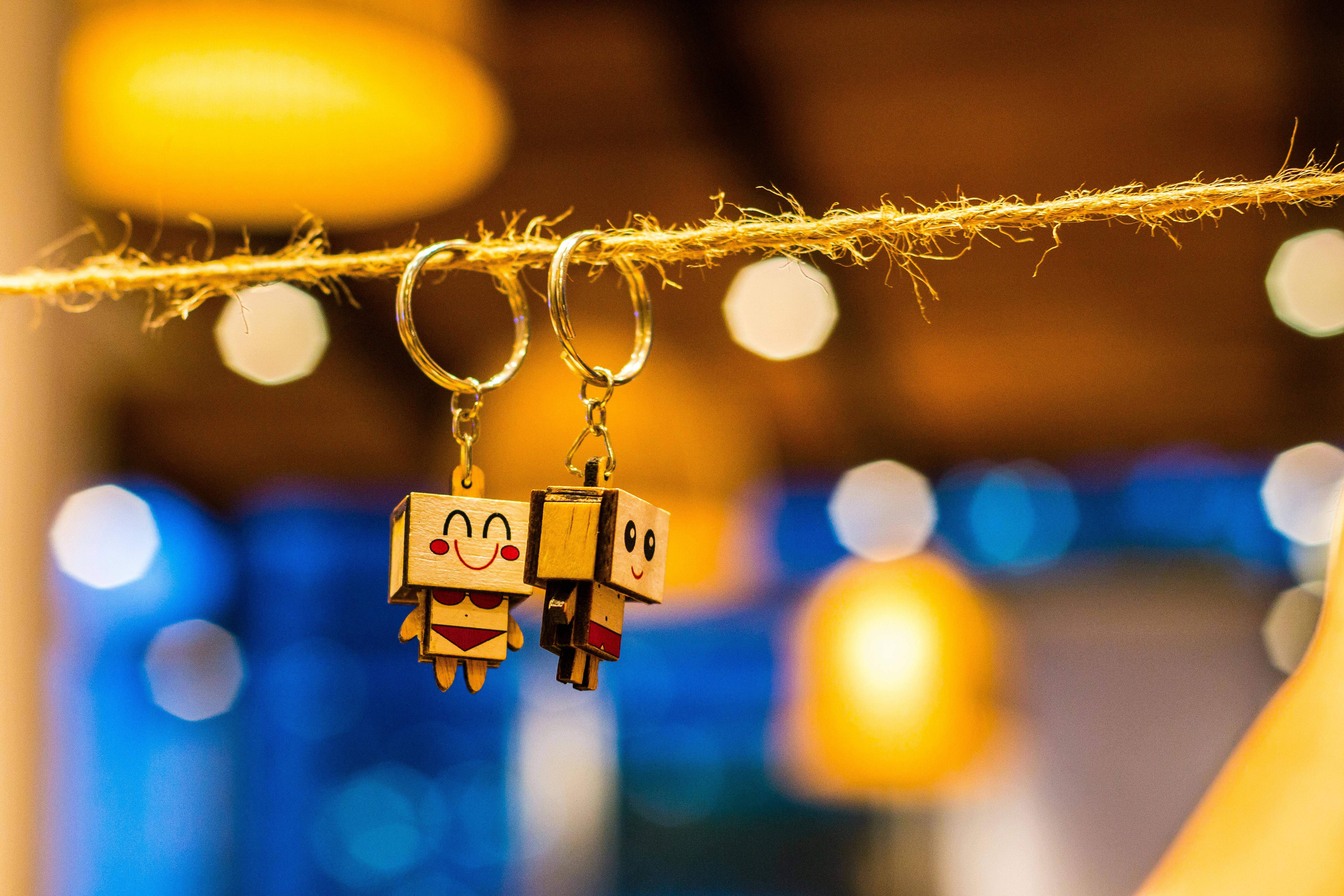 圣经有矛盾的地方吗? Close-up of cute toy keychains hanging on a string with bright bokeh lights in the background.