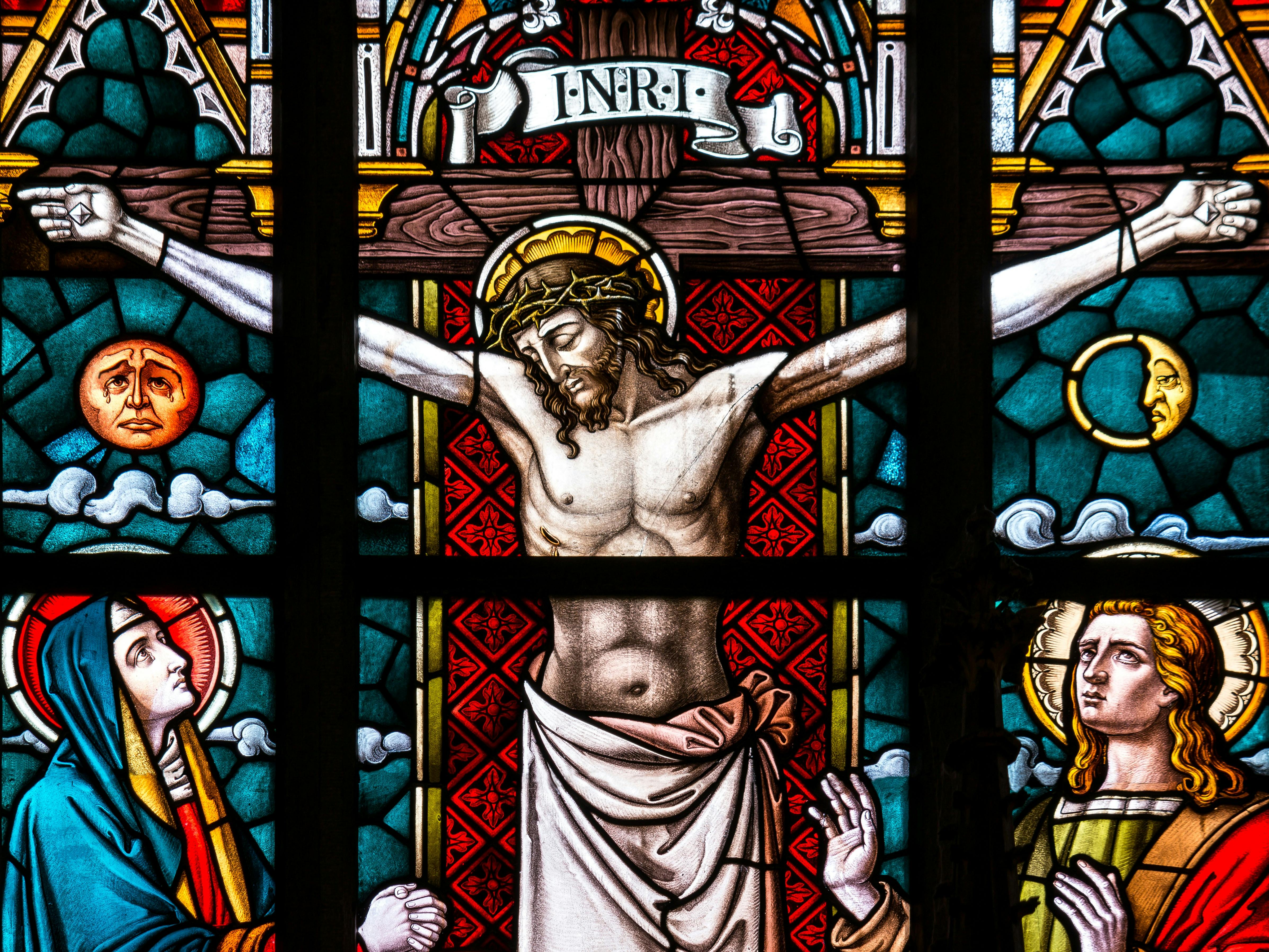 每日随读 Detailed stained glass depiction of the crucifixion featuring Christ and religious icons.